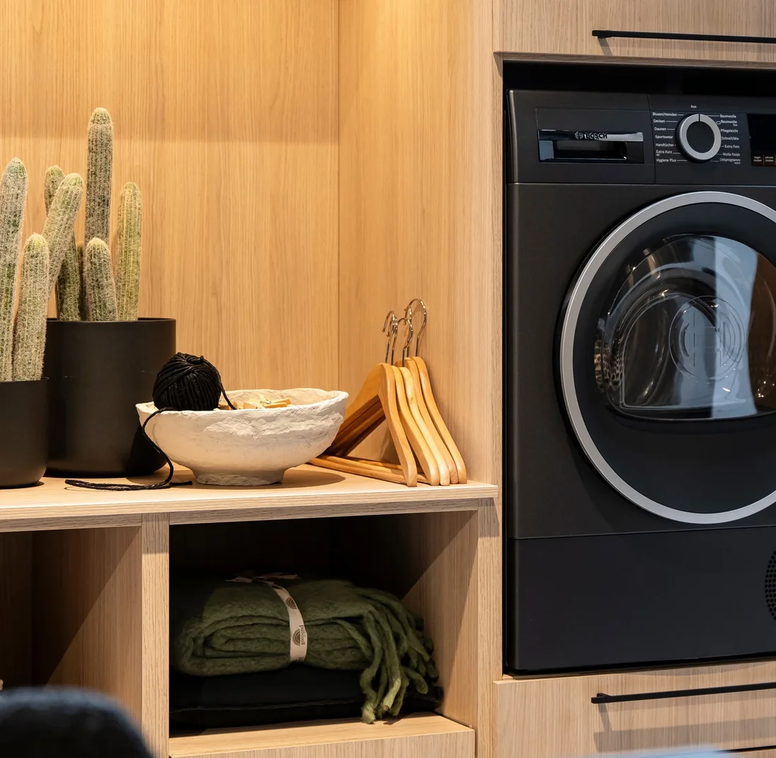 Zona de lavado con lavadora Bosch integrada en mobiliario de madera, por Itek en Bilbao