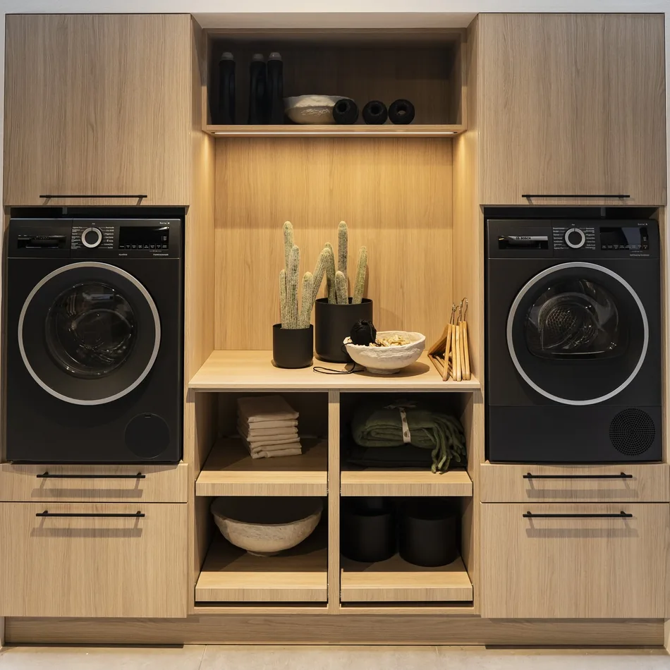 Zona de lavado con lavadora y secadora integradas en mobiliario de madera, por Itek en Bilbao