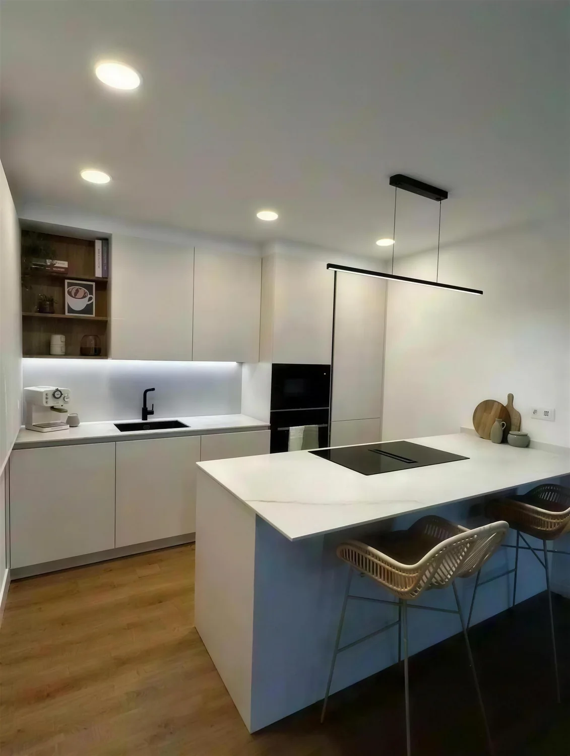 Cocina blanca con isla y campana negra reformada por Itek en Bilbao