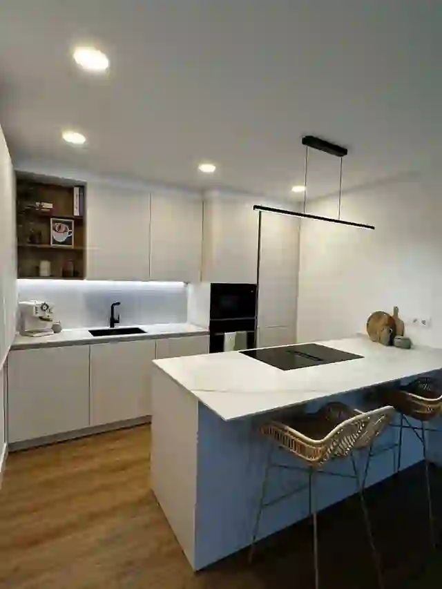 Cocina blanca con isla y campana negra reformada por Itek en Bilbao
