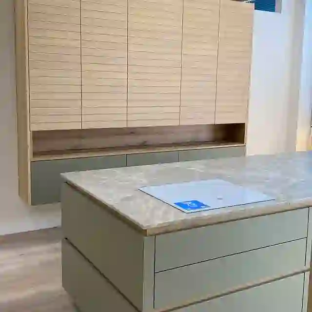 Cocina clara con isla y encimera de piedra instalada por Itek en Bilbao
