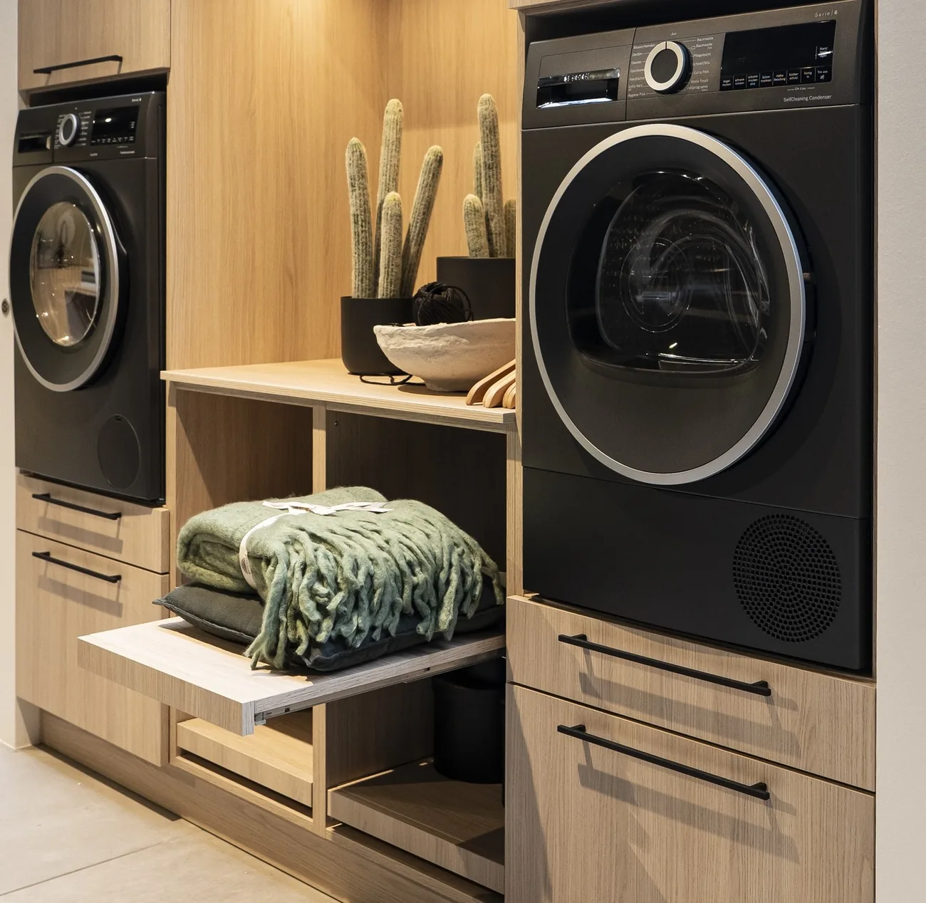 Zona de lavadero con electrodomésticos integrados en mobiliario de madera, por Itek en Bilbao